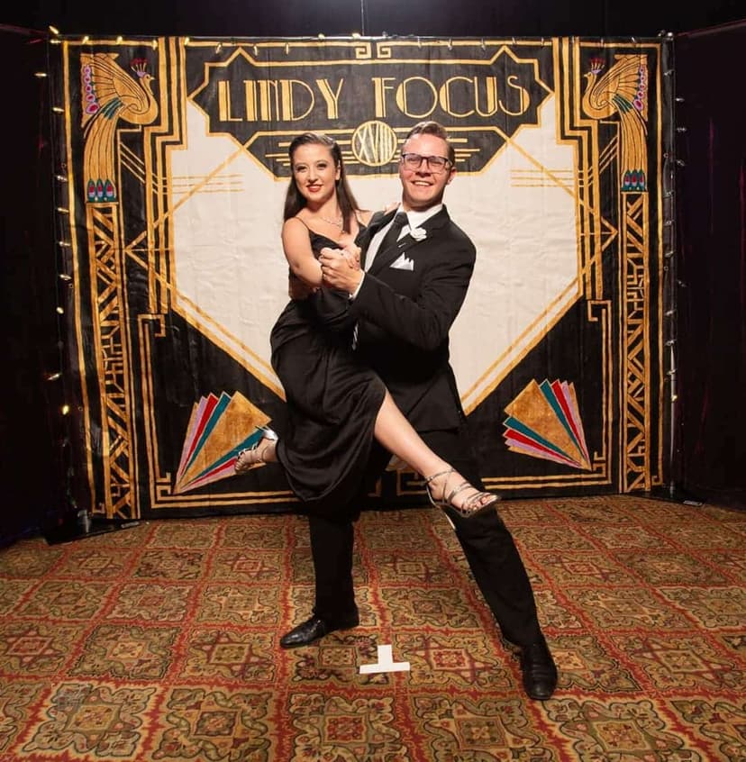 Geoff Newell and his partner posing in front of the Lindy Focus backdrop