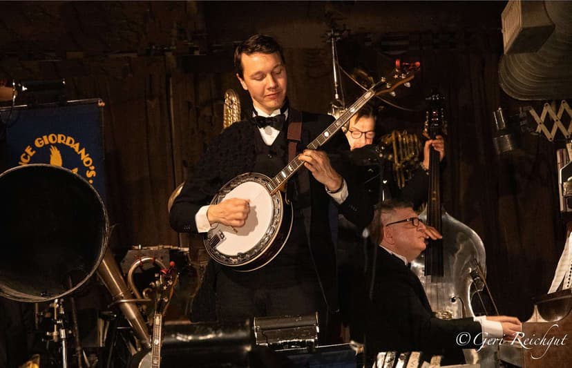 Arnt Arntzen playing banjo on stage with Vince Giordano and the Nighthawks